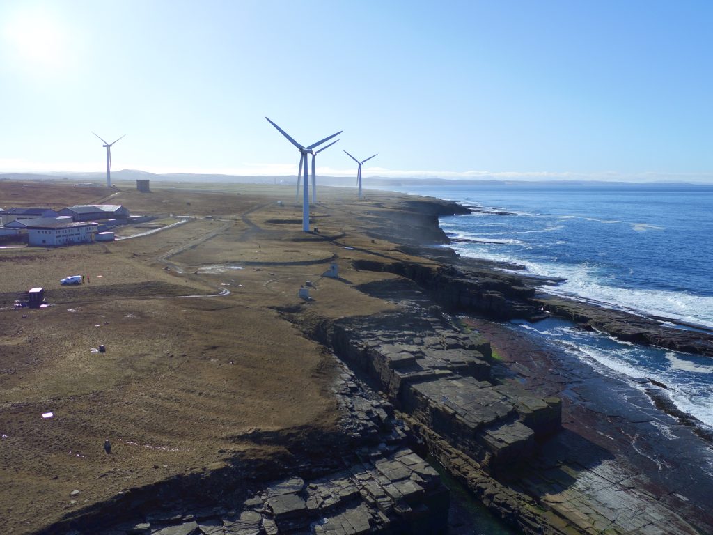 An aerial photo of Forss Business and Energy Park, showing off the stunning natural scenery and several wind turbines